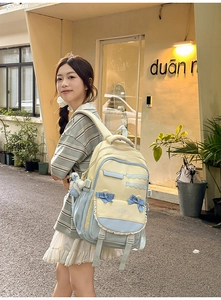 Detail of school backpack featuring lace trim, bow decoration and wind embroidery