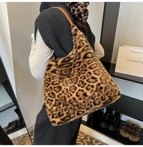 Detail of leopard print faux fur tote bag with brown straps worn on shoulder