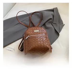 Dettaglio della trama in pelle PU marrone intrecciata e tasca frontale con zip dello zaino