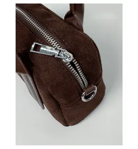 Close-up of high-quality silver metal zipper and brown suede texture on a bowling bag