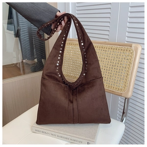 Détail d'un sac fourre-tout en daim marron foncé avec des clous argentés et un style rétro