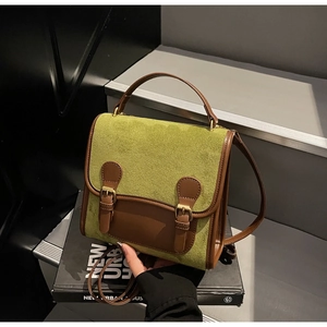 Detail view of moss green frosted suede backpack with brown leather trim and twin buckles