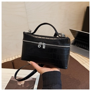 Detail of black crocodile texture vanity case with silver zipper and top handle
