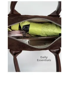 Top view of large capacity dark brown suede bag interior showing daily items storage