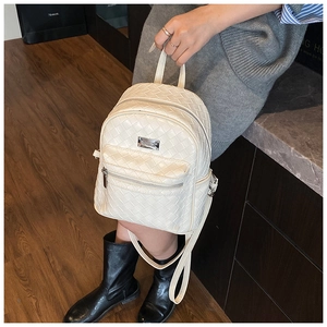 Dettaglio del mini zaino beige con trama intrecciata e chiusura a zip argentata