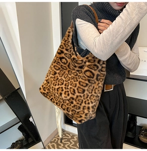 Detailed macro view of plush leopard print faux fur texture and brown leather strap on tote
