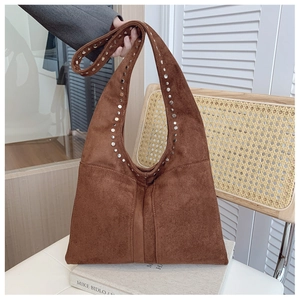 Détail du sac cabas vintage en daim marron avec rivets argentés et design rétro en U