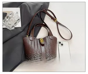 Dettaglio borsa a secchiello intrecciata marrone scuro con chiusura in metallo vintage