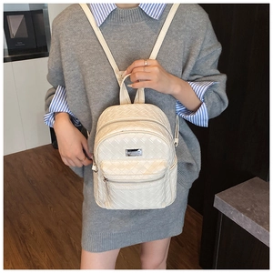 Dettaglio mini zaino beige intrecciato con cerniere in metallo argento e placca logo