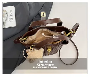 Dettaglio dell'interno della borsa a secchiello intrecciata con tasca principale e zip