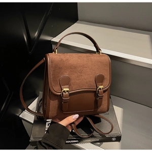 Detail of vintage brown frosted backpack with dual textures and metal buckle straps
