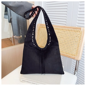 Détail du sac cabas en daim noir avec rivets argentés et structure hobo souple de mode