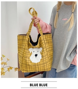 Detail of yellow plaid tote bag with cute white dog patch and woven fabric texture