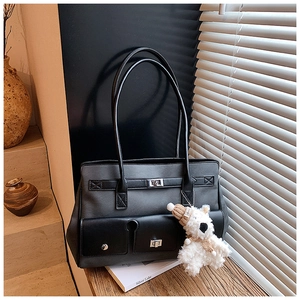 Close-up of dual-tone tote bag with silver twist lock and cute teddy bear pendant charm