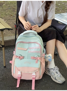 Outdoor shot of the pastel green and pink backpack with lace and bow details