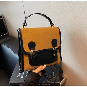Macro detail of retro dual-material backpack with matte brown finish and black buckles