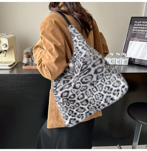 Detailed texture of leopard print faux fur tote bag with slim black leather shoulder strap