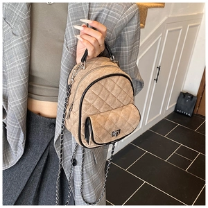 Close-up of quilted khaki suede mini backpack with silver chain and twist-lock detail