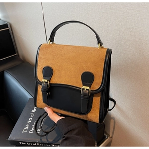 Detail of vintage matte brown backpack with black trim and gold buckle accents
