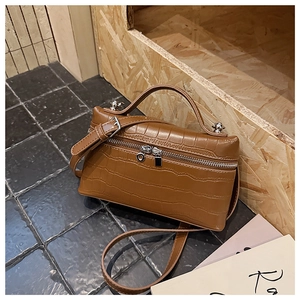 Detailed view of crocodile embossed leather handbag with dual zippers and silver hardware