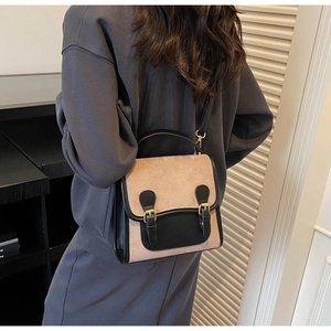 Detailed view of vintage beige suede backpack with black leather trim and dual buckles