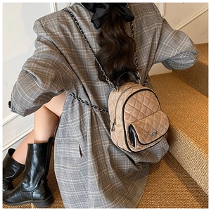 Detail of khaki quilted suede mini backpack with gold chain straps on a model