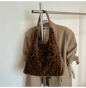 Close-up of leopard print faux fur tote bag hanging with camel blazer and knitwear
