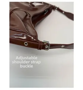 Detailed close-up of the adjustable strap buckle on a dark brown leather backpack