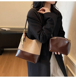 Détail du sac cabas en daim minimaliste et pochette assortie avec charme en perles de bois