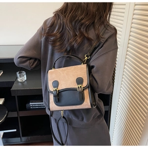 Detail of vintage frosted brown suede handbag with black leather trim and metal buckles