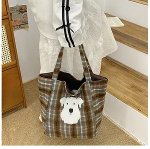 Detail of checkered plaid tote bag featuring a cute white schnauzer embroidery patch