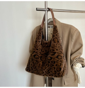 Close-up of leopard print faux fur tote bag with brown faux leather straps on a hanger