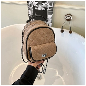 Close-up of quilted mini backpack with suede finish and silver twist-lock closure