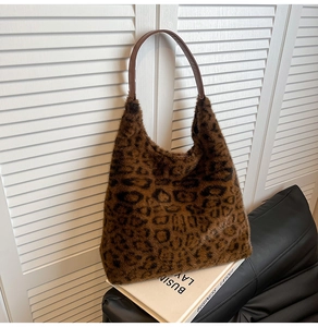 Detail of plush leopard print tote bag with brown faux leather handles for autumn