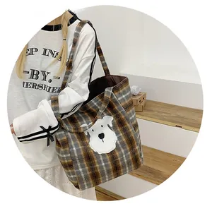 Detail of checkered tote bag featuring a cute dog patch and spacious interior