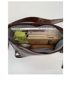 Top-down view of a spacious brown tote bag interior with striped lining and large capacity