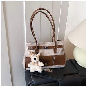 Detail of vintage canvas tote bag with leather trim and cute teddy bear charm