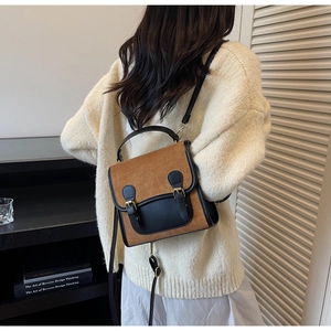 Detail of vintage square backpack with brown suede and black leather straps on model