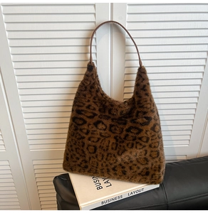 Detail of plush leopard print tote bag with soft faux fur texture and slim brown shoulder strap