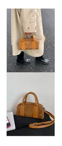 Detail of caramel suede bowling bag with yellow leather handles and silver hardware