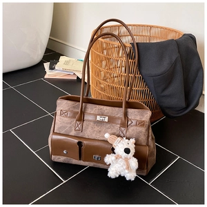 Detail of vintage tote bag with large pockets and a cute teddy bear plush charm