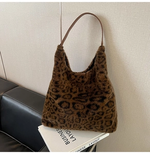 Detailed close-up of fluffy leopard print faux fur texture and leather strap on a tote bag