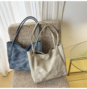 Minimalist faux leather tote bags with textured finish shown on a wicker chair
