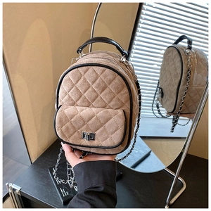 Detail of khaki quilted mini backpack with chain strap and elegant matte suede finish