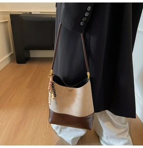 Détail d'un sac cabas rétro en cuir mat beige et marron avec perles décoratives en bois