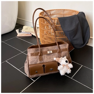 Close-up of marble texture tote bag with vintage metal turn-lock and plush bear charm