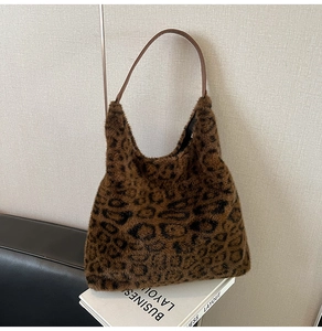 Detailed view of leopard print plush tote bag showing soft faux fur texture and leather strap