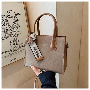 Détail de la texture tressée marron sur un petit sac carré avec bandoulière en tissu