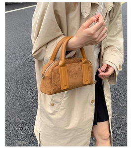 Brown suede bowling bag details with smooth leather handles and metal D-ring attachment