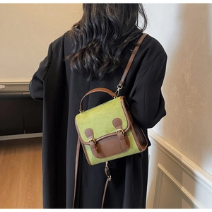 Close-up of vintage avocado green suede backpack with brown leather trim and metal buckles